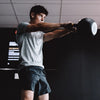 Person lifting a kettlebell in a gym setting