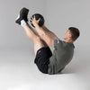 Person performing an exercise with a slam ball on a gray background