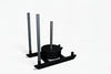 Black weight plates loaded onto a commercial power sled on a white background