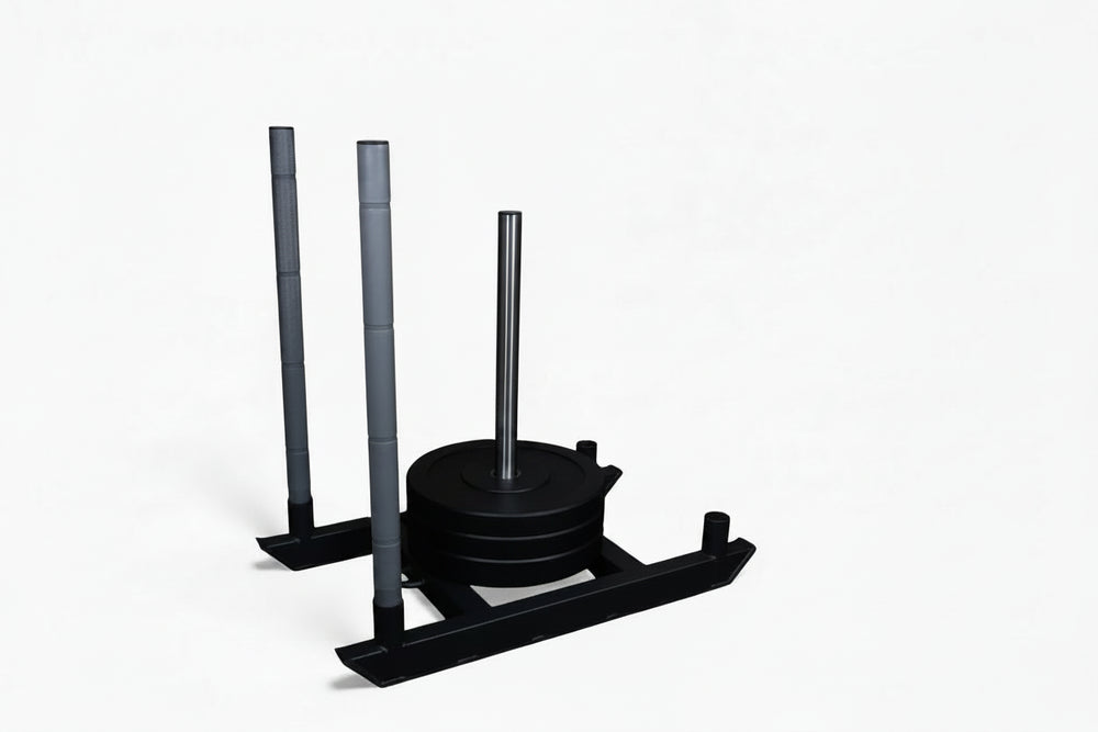 Black weight plates loaded onto a commercial power sled on a white background