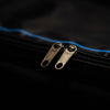 Close-up of a black bag with metal zippers
