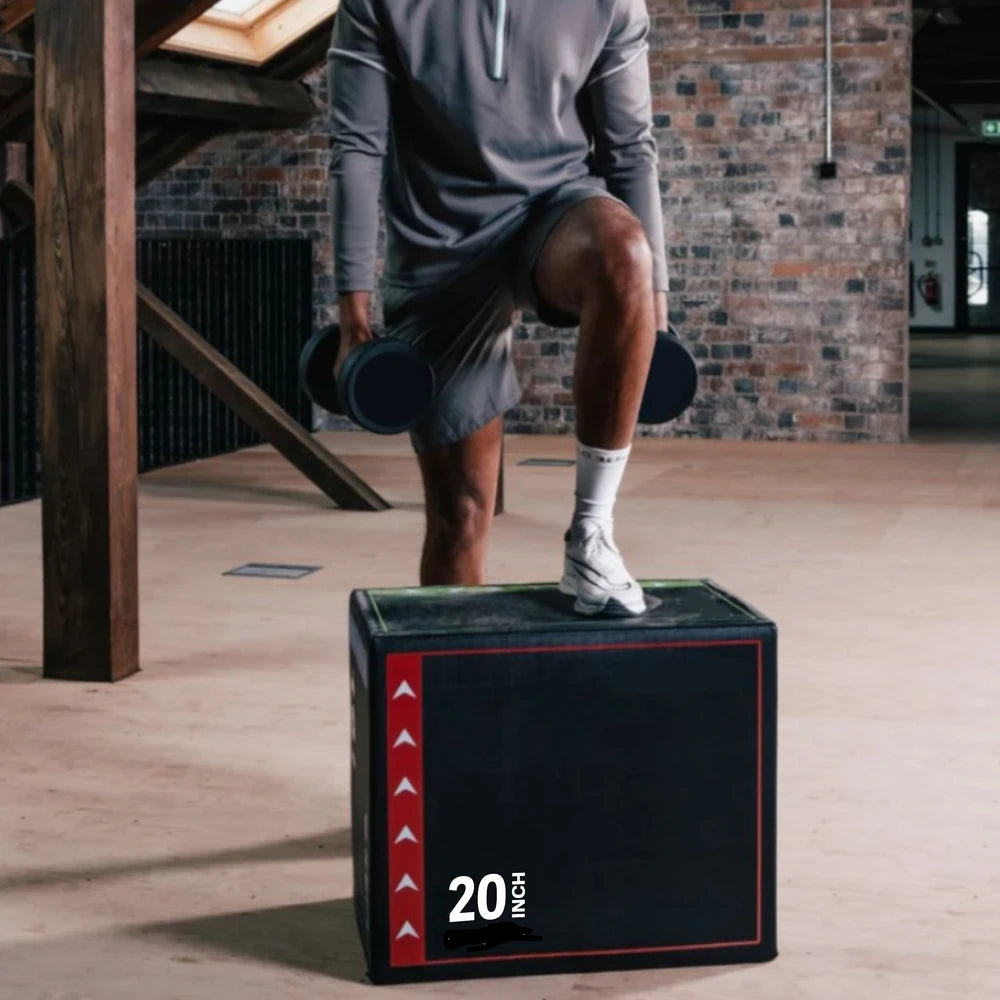 Person performing a box jump on a 20-inch box in a gym setting.