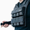 Person wearing a black weighted vest on a white background