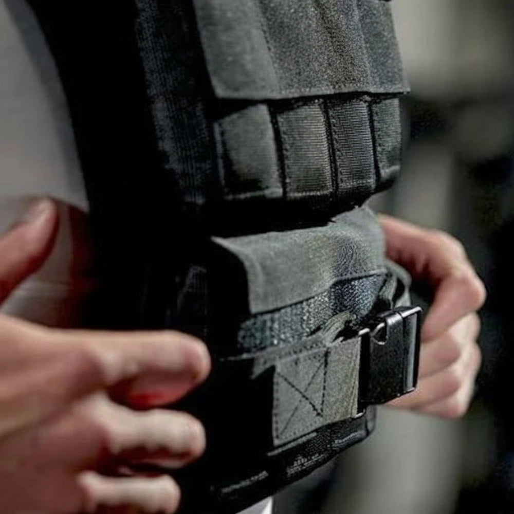 Person adjusting a black weight gym vest