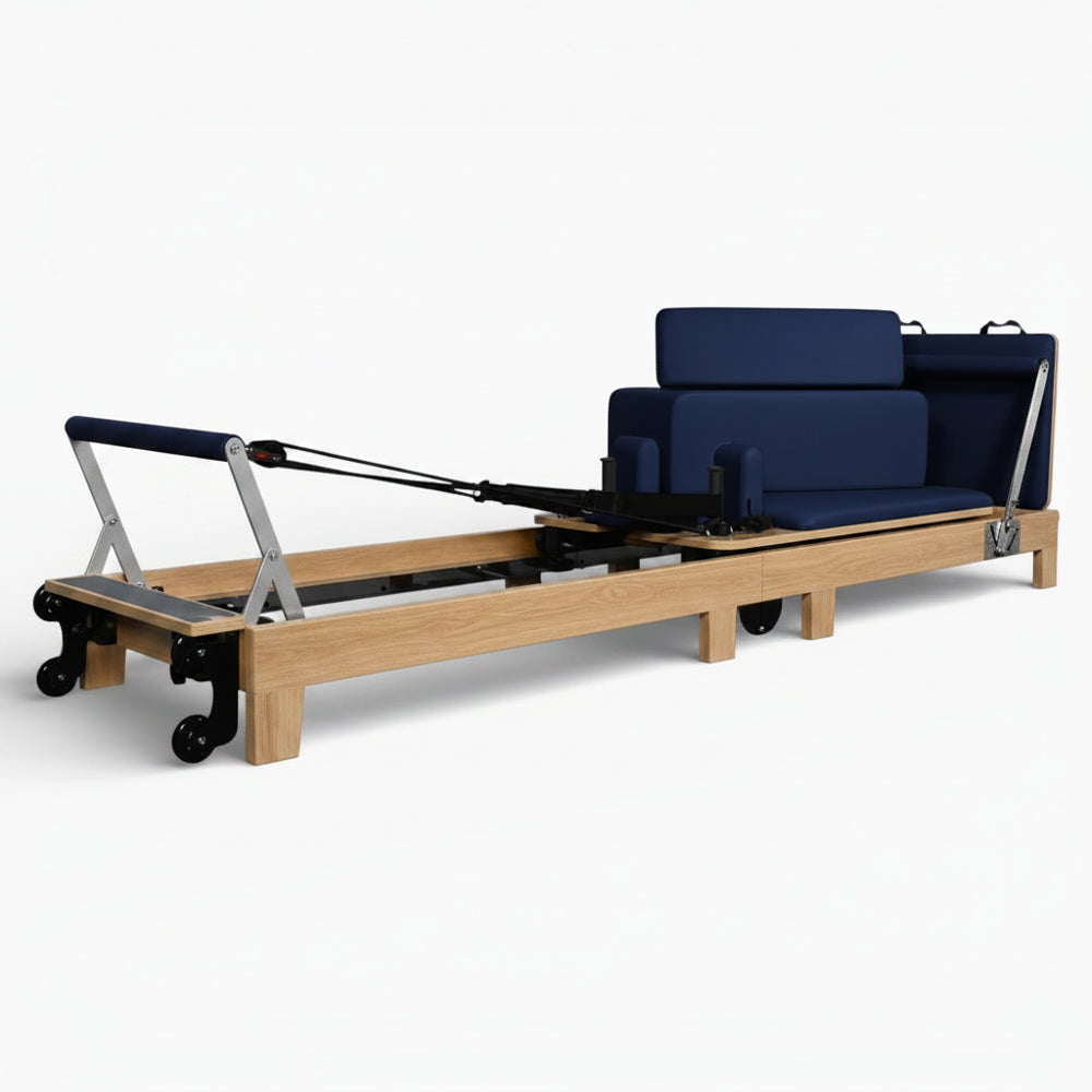 Pilates reformer with wooden frame and blue cushion on a white background