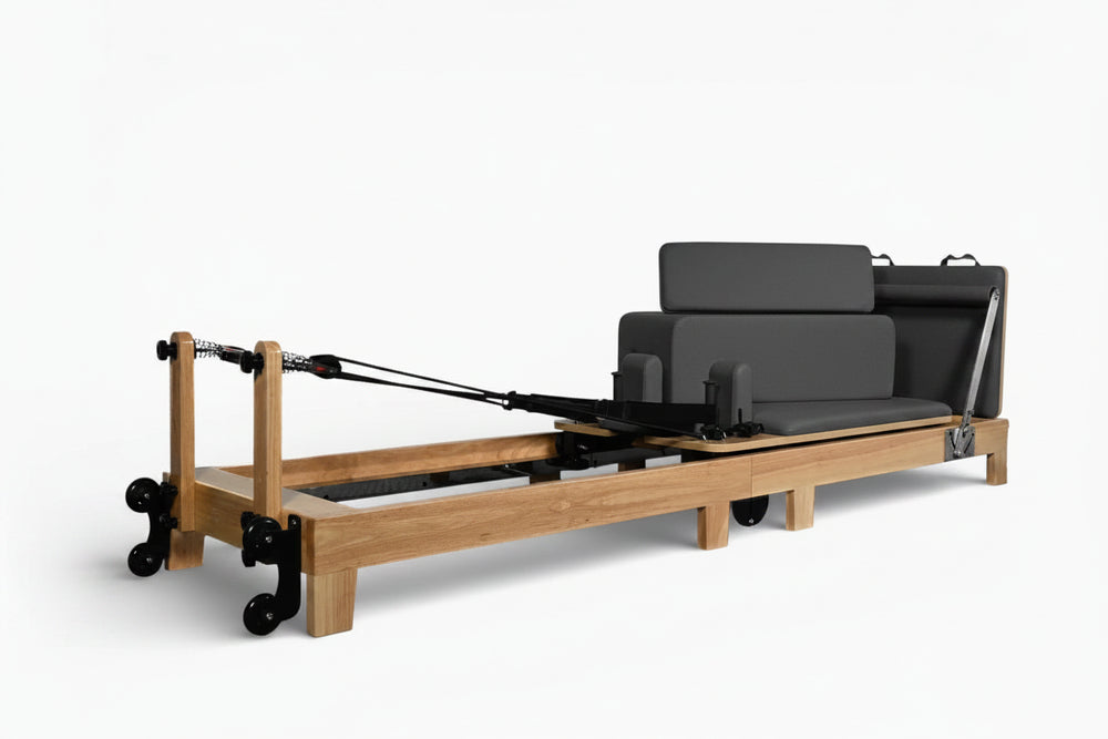 Wooden reformer with black cushion on a white background
