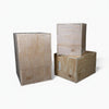 Three wooden jump boxes of different sizes stacked on a white background