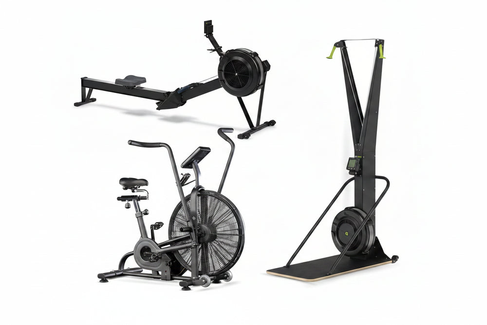 Three pieces of exercise equipment on a white background: a rowing machine, an air bike, and a ski eg