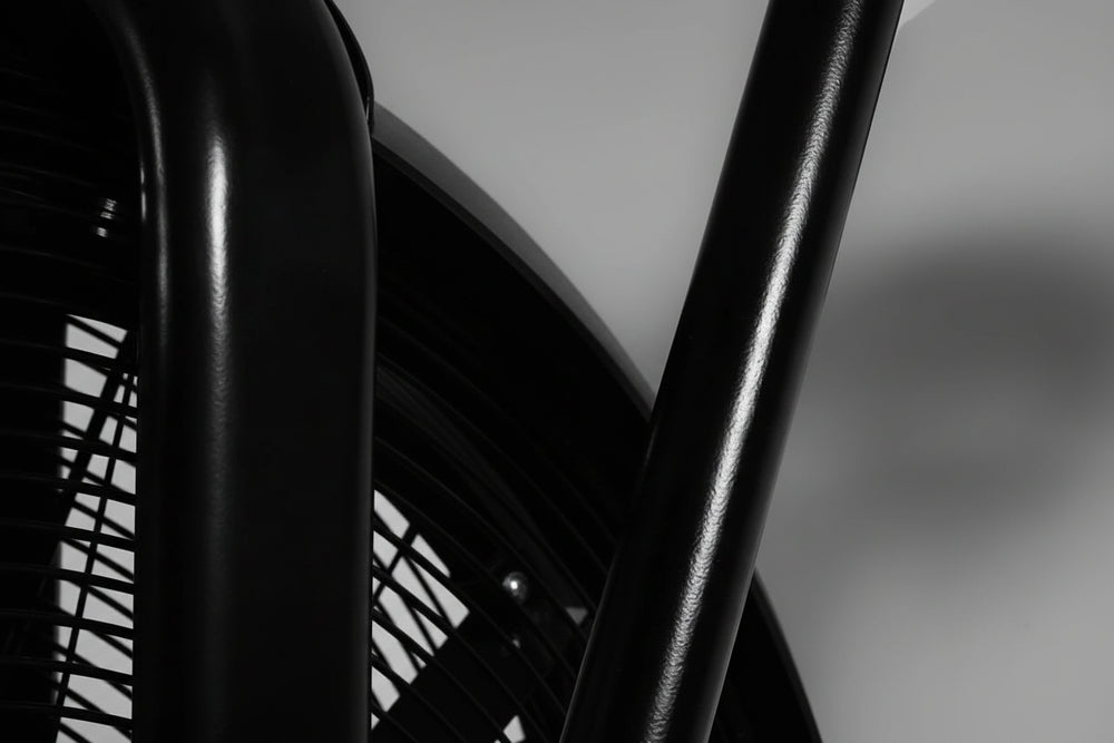 Close-up of a black exercise bike on a blurred background