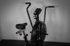 Black exercise bike with digital display on a gray background