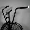Black exercise bike with large wheels on a gray background
