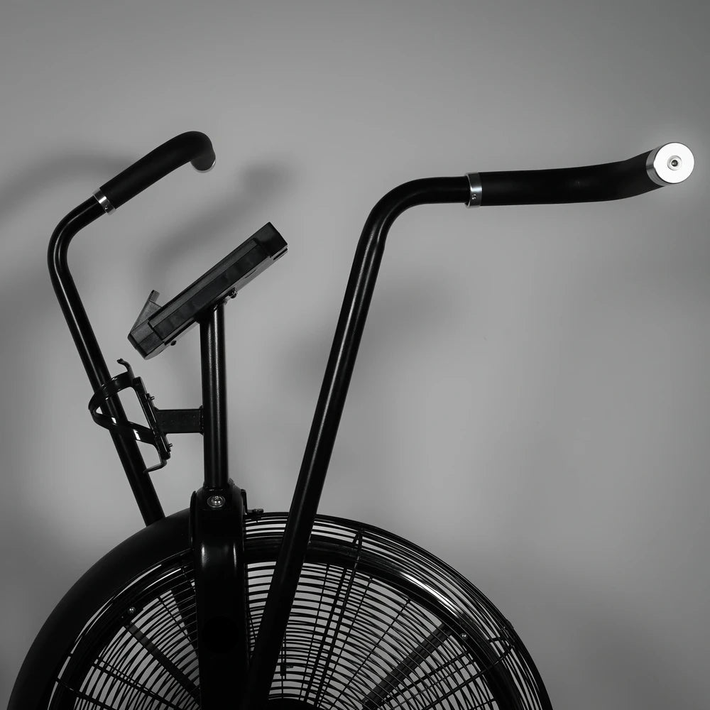 Black exercise bike with large wheels on a gray background