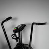 Black exercise bike with handlebars and control panel on a gray background
