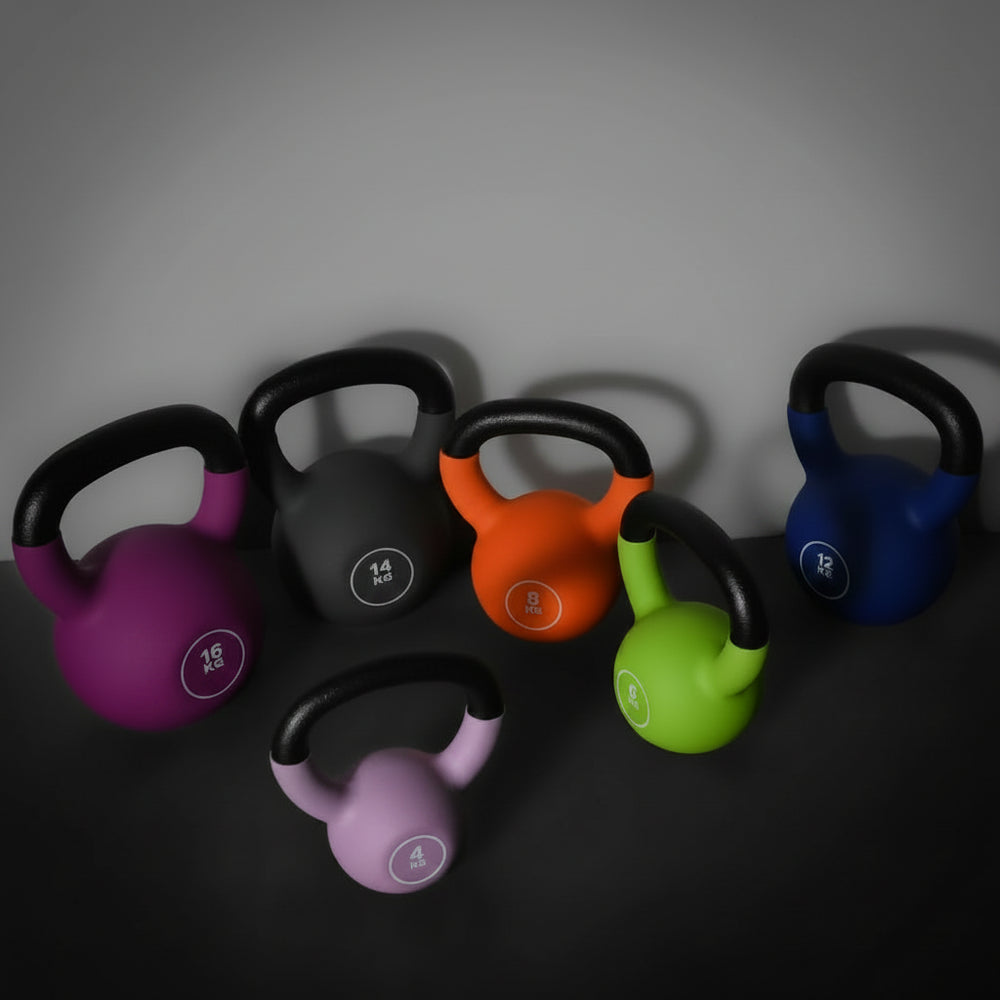 Set of colorful kettlebells on a dark surface with a gray background