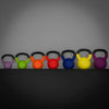 Row of colorful kettlebells on a dark surface with a gray background
