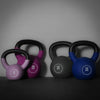 Set of colorful kettlebells with weight markings on a dark background