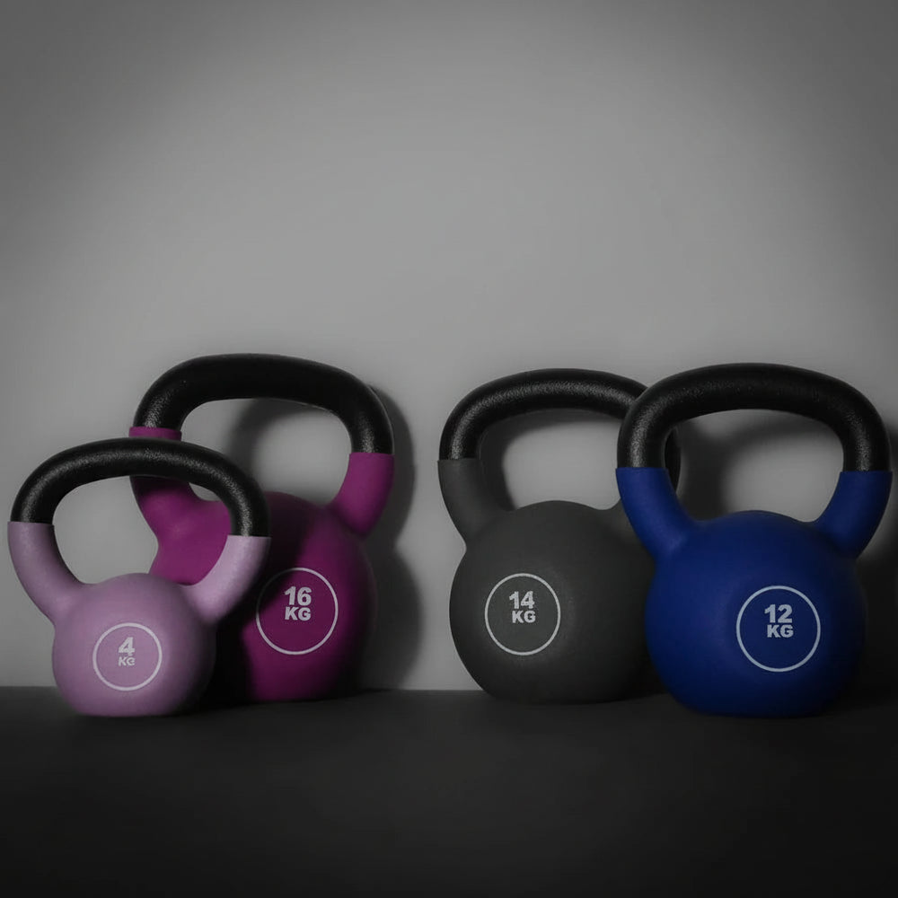 Set of colorful kettlebells with weight markings on a dark background