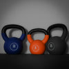 Three kettlebells in blue, orange, and black with weight markings on a dark background