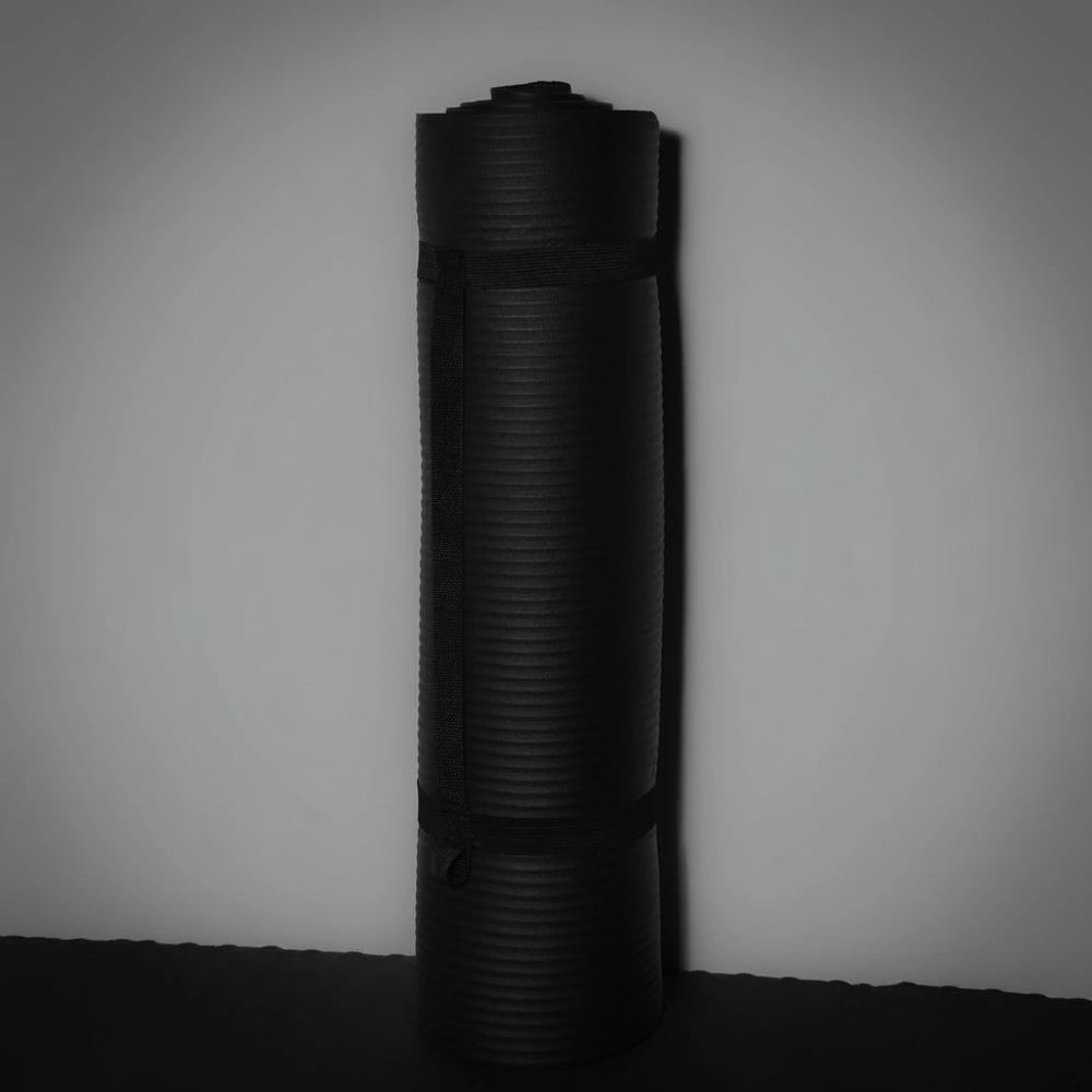 Black rolled-up gym mat on a gray background