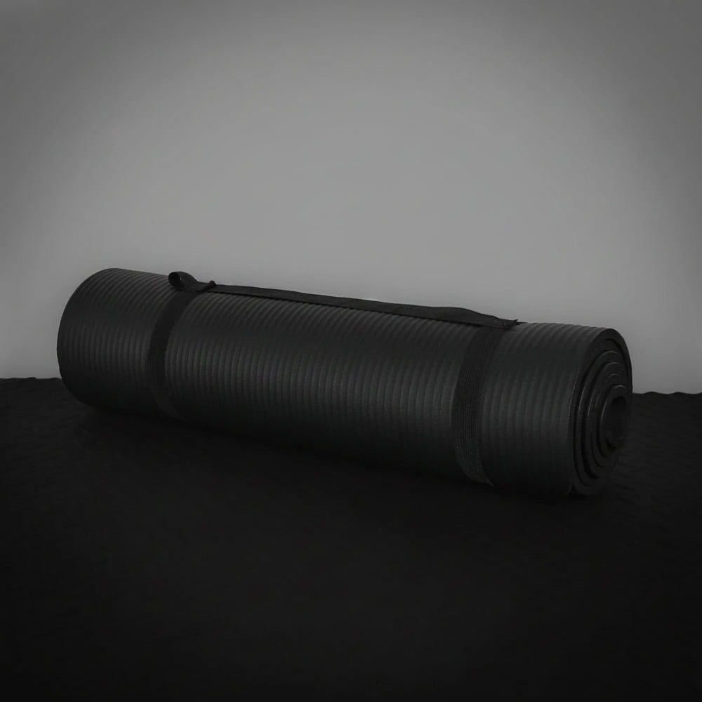 Black exercise mat rolled up on a dark background
