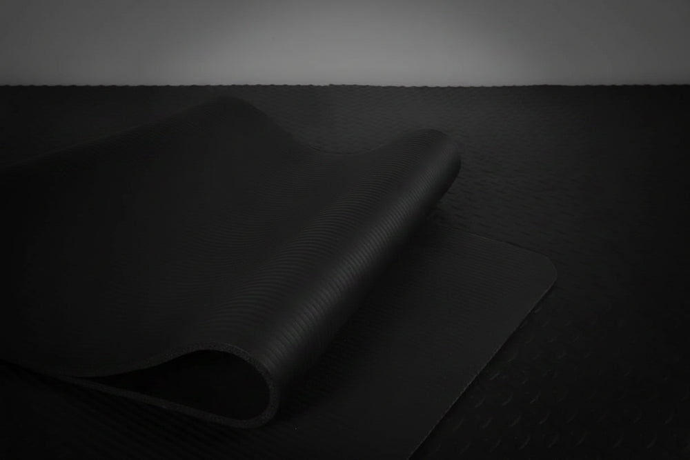 Black yoga mat on a dark background