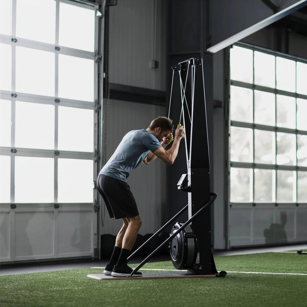 Person using a black ski erg exercise machine in a gym setting