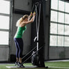 Woman exercising on a ski erg exercise equipment in a gym setting.