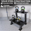 Black metal kettlebell stand with kettlebells on a gray floor, emphasizing solid steel construction.