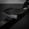 Black seat of a rowing erg machine on a dark background