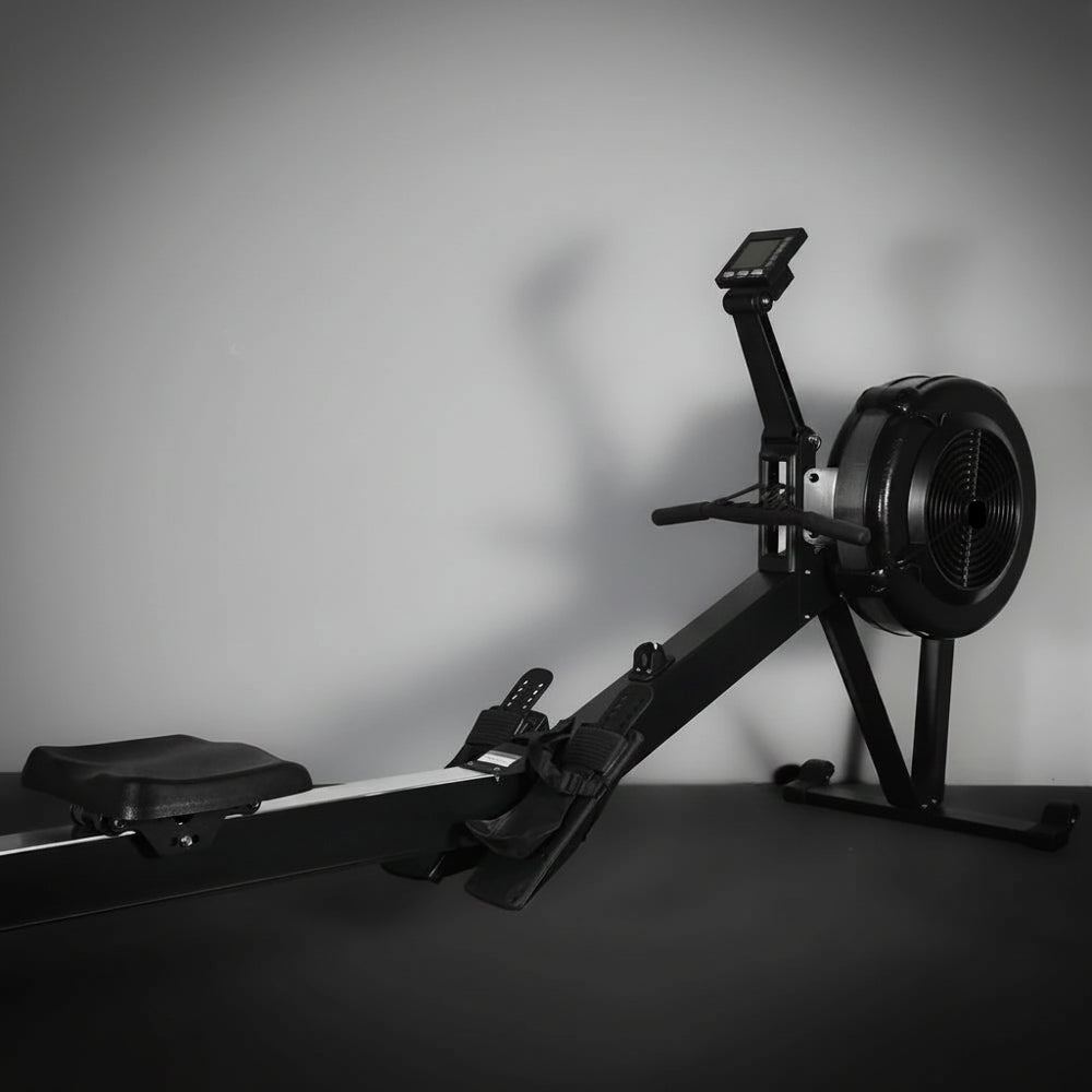 Commercial rowing erg machine with a black seat and digital display on a gray background