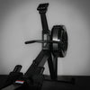 Black rowing machine against a gray wall