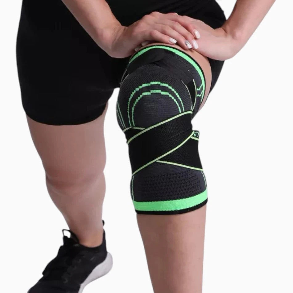 Person wearing a black and green knee brace on a white background