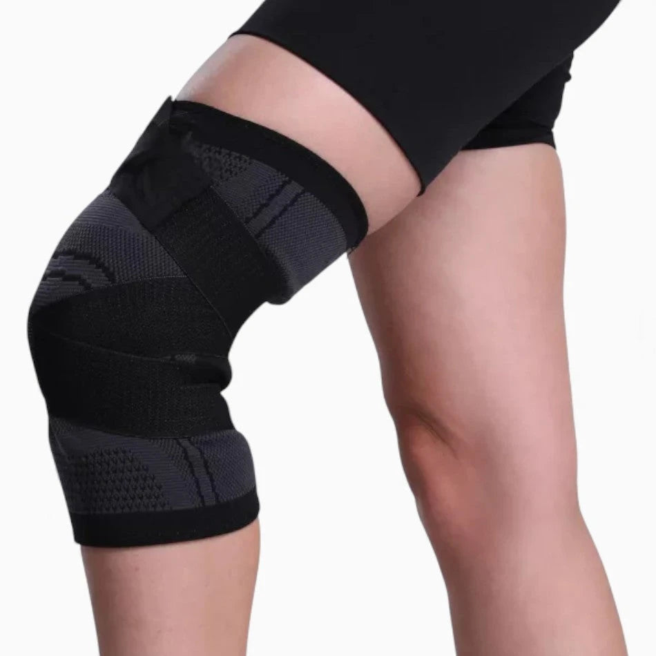 Black knee brace on a person's knee against a white background