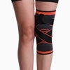 Black and orange knee brace on a person's leg against a white background