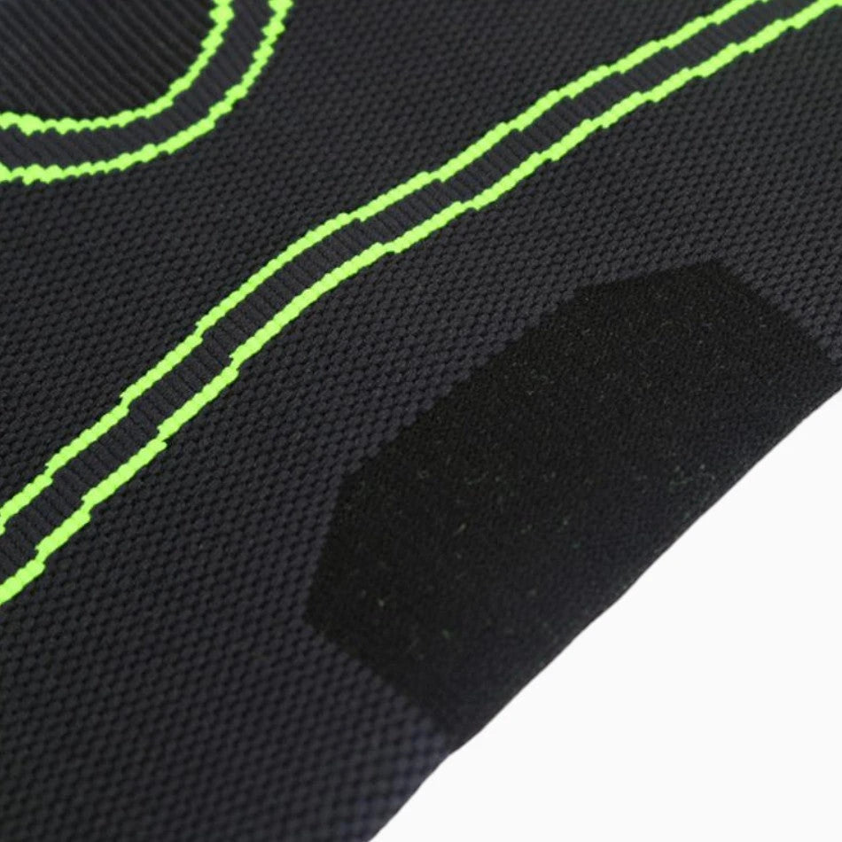 Close-up of black fabric with green stitching on a white background