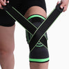 Person wearing a black and green knee brace on a plain background