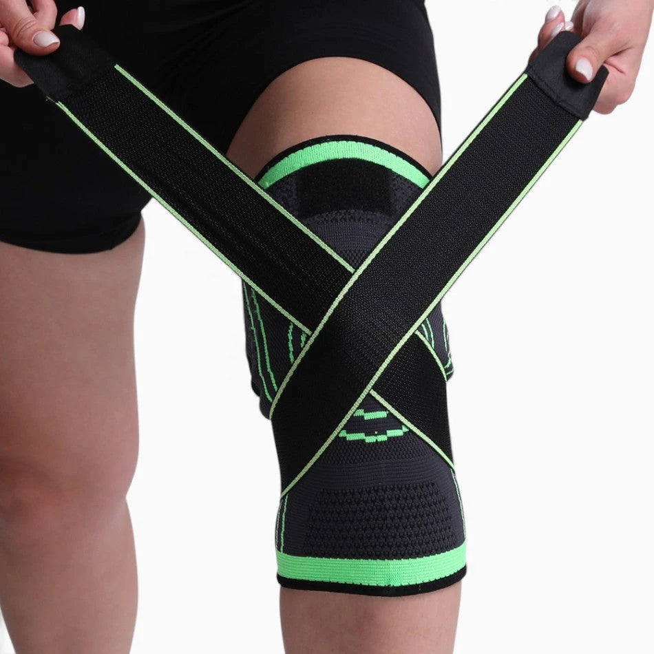 Person wearing a black and green knee brace on a plain background