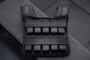 Black weight vest on a gray background