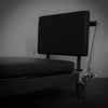 Black pilates reformer machine on a dark background