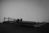 Black Pilates reformer on a dark background