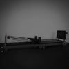 Gym Pilates reformer machine against a plain wall