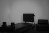 Black pilates reformer against a plain wall.