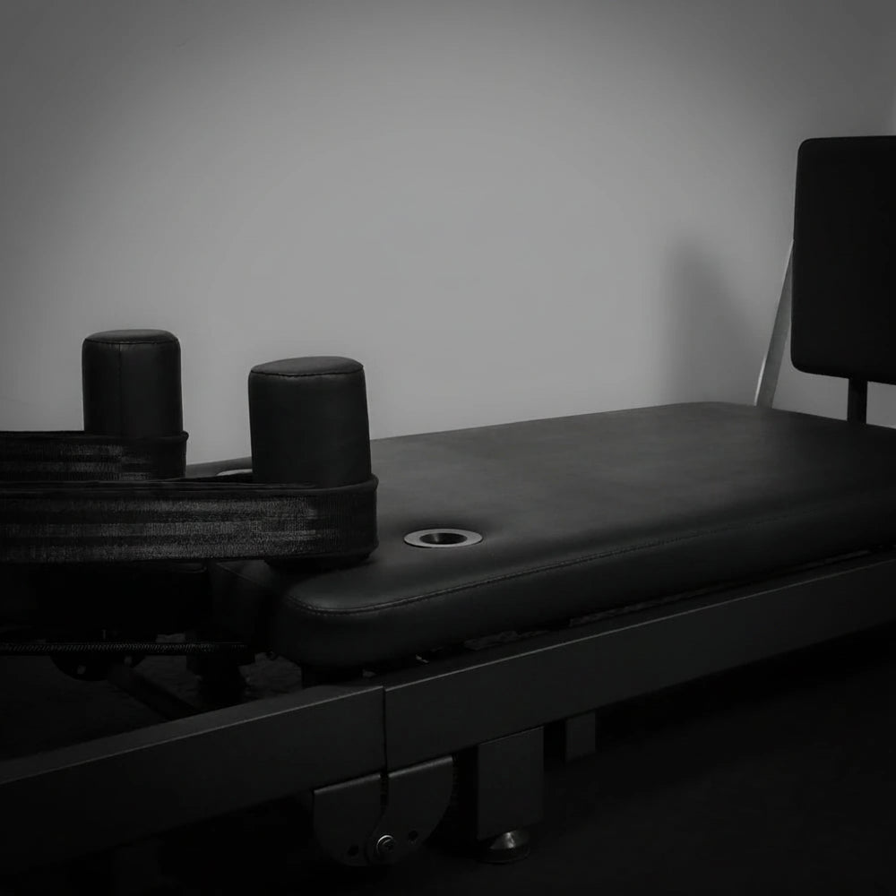 Black pilates reformer on a grey background