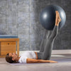 Woman exercising with a stability ball on a mat in a home setting