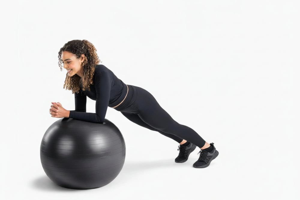 Woman exercising on a black exercise ball on a white background