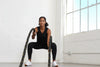 Woman exercising with battle ropes in a bright room