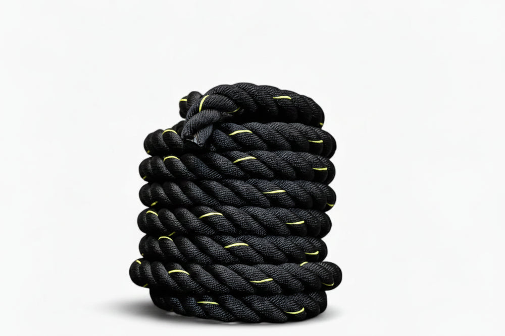 Coiled black battle rope on a white background