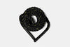 Coiled black battle rope with yellow accents on a white background