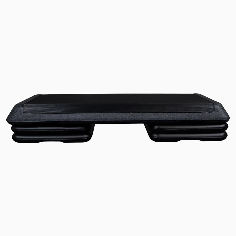 Black aerobics stepper with height adjustment on a white background