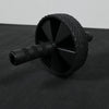 Black ab roller on a black surface with a gray background